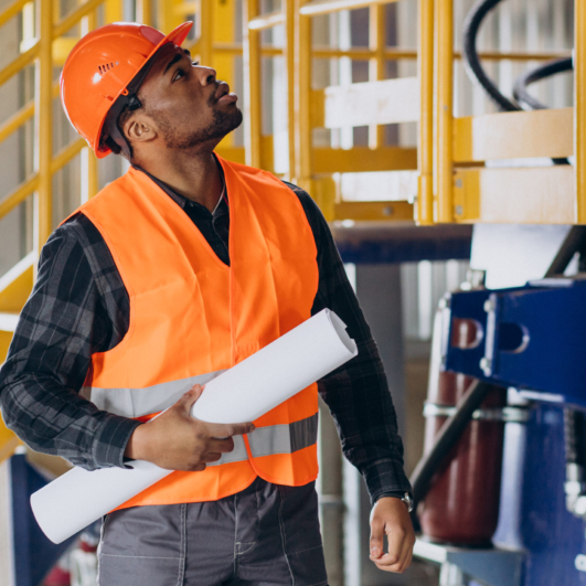 African american worker standing in uniform wearing a safety hat in a factory